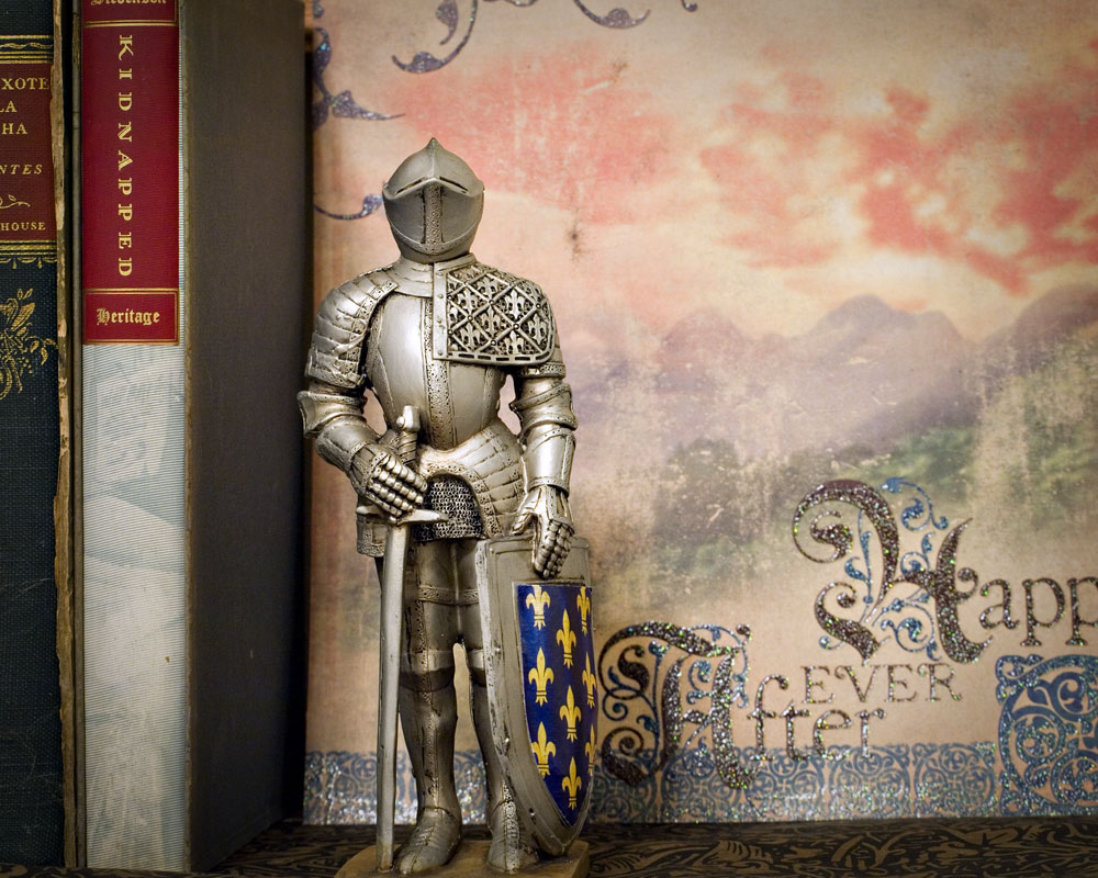 knight figure on shelf next to books with decorative paper background