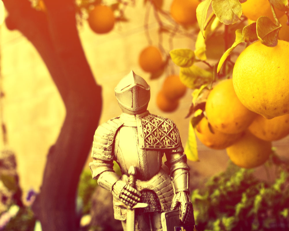 knight figure in golden sunset with loaded orange tree