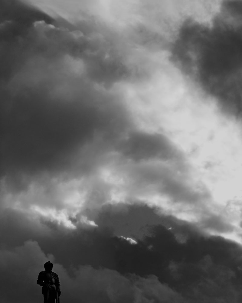 knight figure silhouetted against cloudy sky