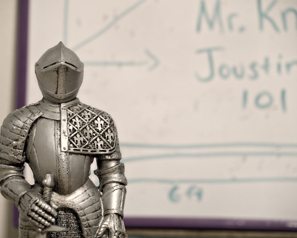 knight figure standing by white board with "Jousting 101" written on it