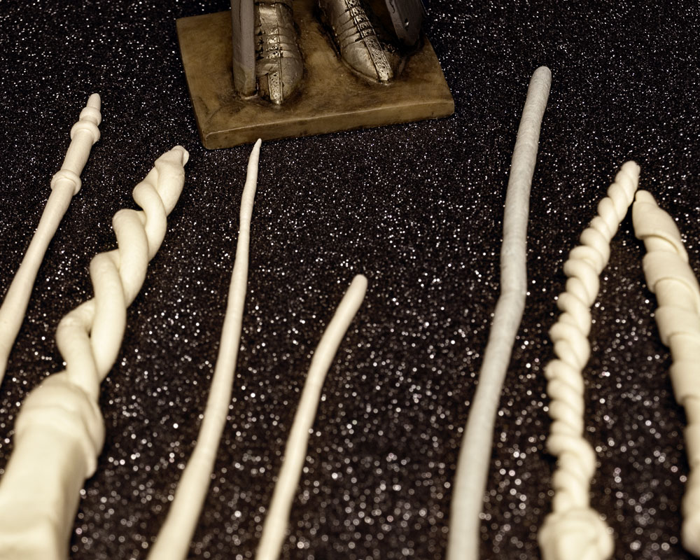 knight figure standing by large clay wands