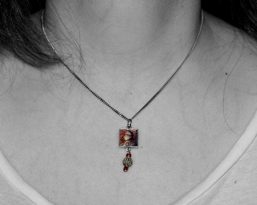 woman's neck wearing necklace that is a picture of knight figure