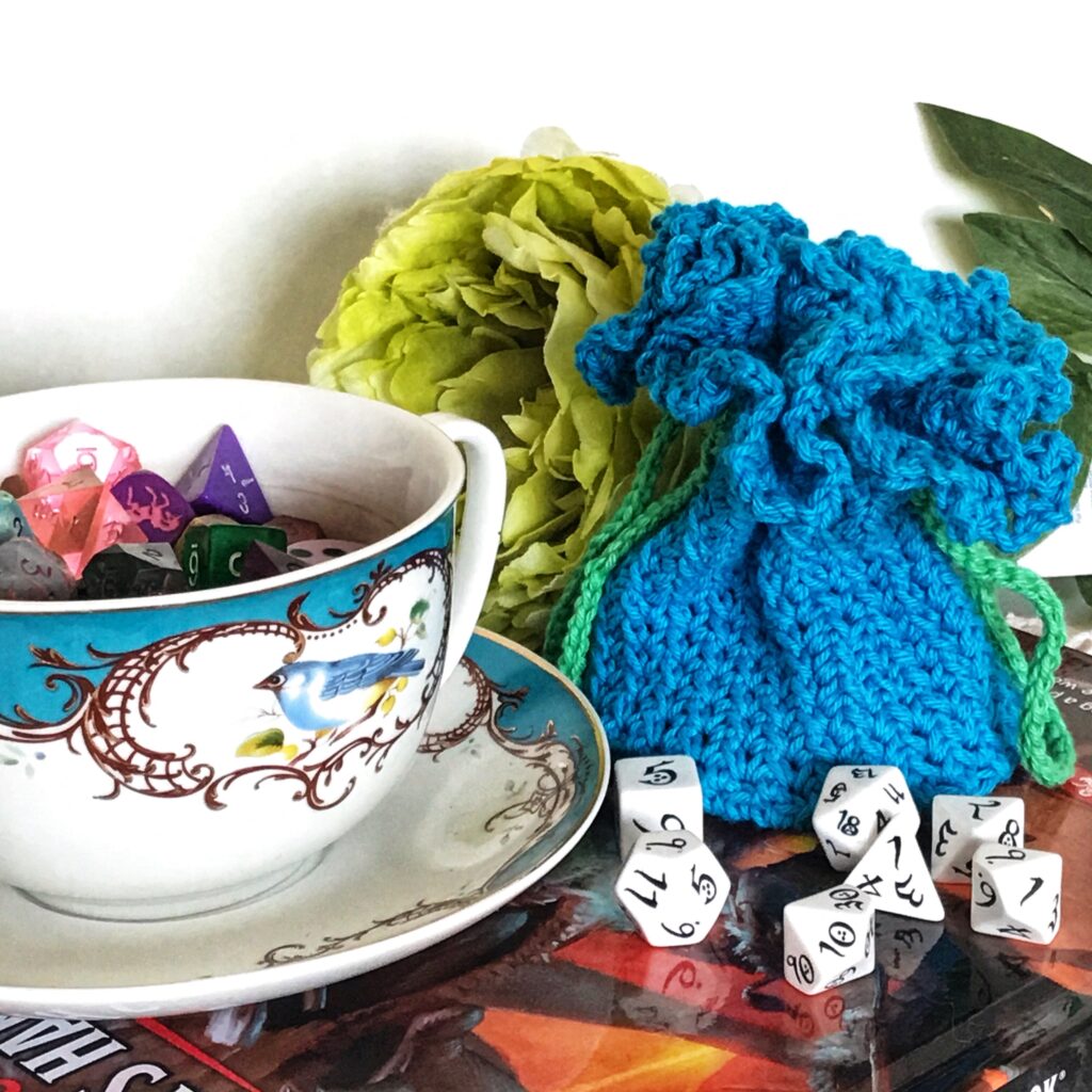 frilly pouch displayed with dice and teacup