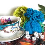 frilly pouch displayed with dice and teacup