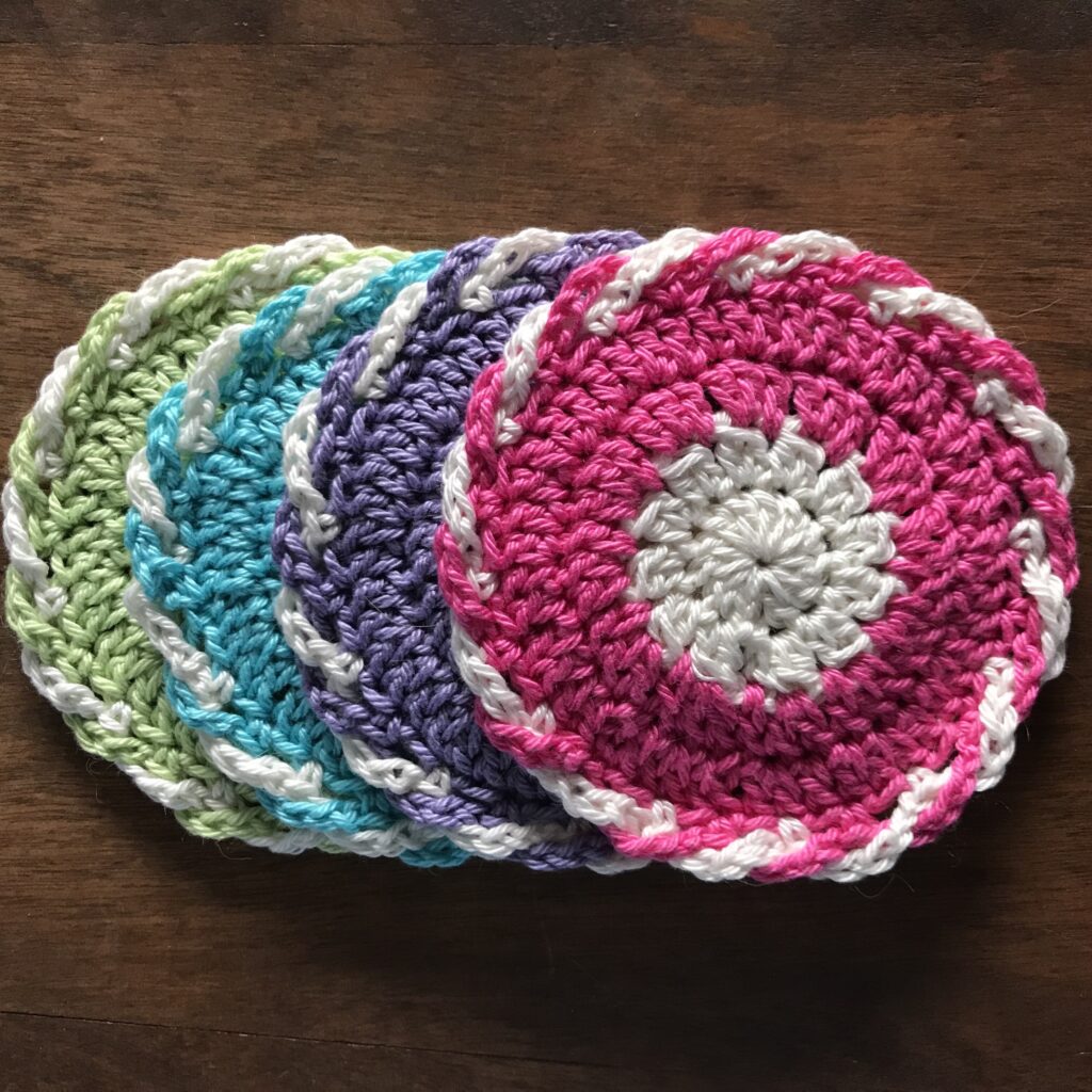 four crocheted coasters in spring colors