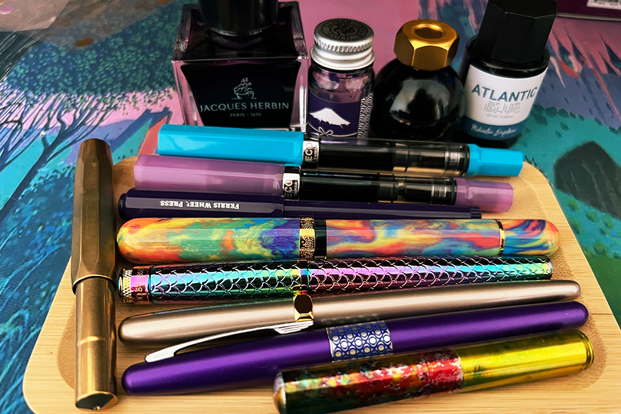 assortment of fountain pens and ink